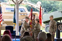 Col. Caleb Lewis, incoming commander, Letterkenny Army Depot, left, receives the flag from Maj. Gen. Lori Robinson, commanding general, U.S. Army Aviation and Missile Command, center, during a change of command ceremony held at the installation’s recreation area, assuming command of LEAD, July 10.