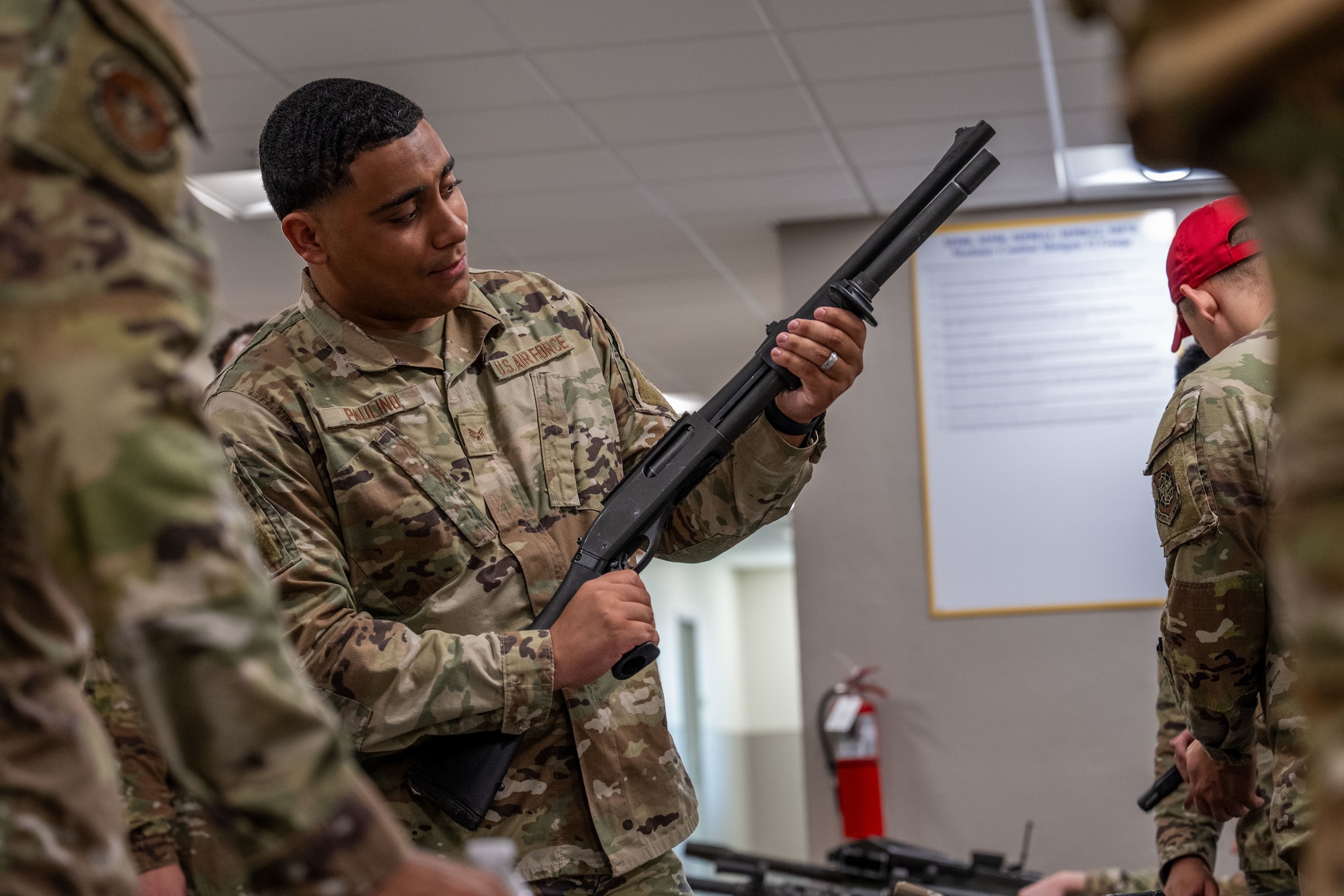 Senior Airman Isaiah Paulino, 22nd Operational Support Squadron commander support staff, holds an M870 shotgun during an Airman Leadership School trip to the Combat Arms Training and Maintenance facility at McConnell Air Force Base, Kansas, July 10, 2025. The trip to CATM allowed the future leaders a hands-on learning experience with handguns, assault rifles and machine guns. (U.S. Air Force photo by Airman 1st Class Paula Arce)
