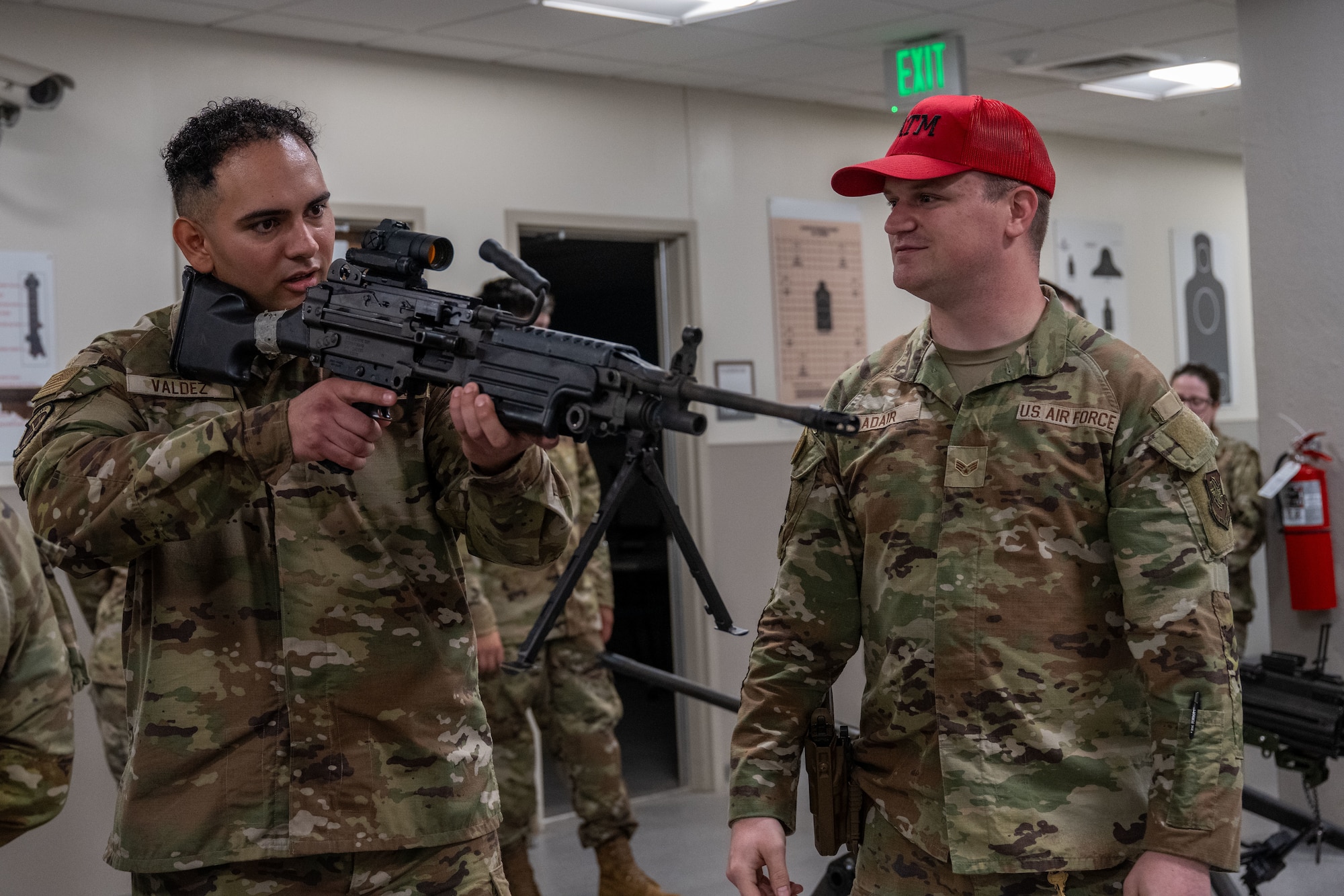 A Combat Arms Training and Maintenance instructor briefs an Airman Leadership School Class 25-F student on the M-249 machine gun during an ALS trip to the Combat Arms Training and Maintenance facility at McConnell Air Force Base, Kansas, July 10, 2025. The field trip, not generally part of the ALS curriculum, gave Airmen from multiple career fields an opportunity to learn about weapons. (U.S. Air Force photo by Airman 1st Class Paula Arce)