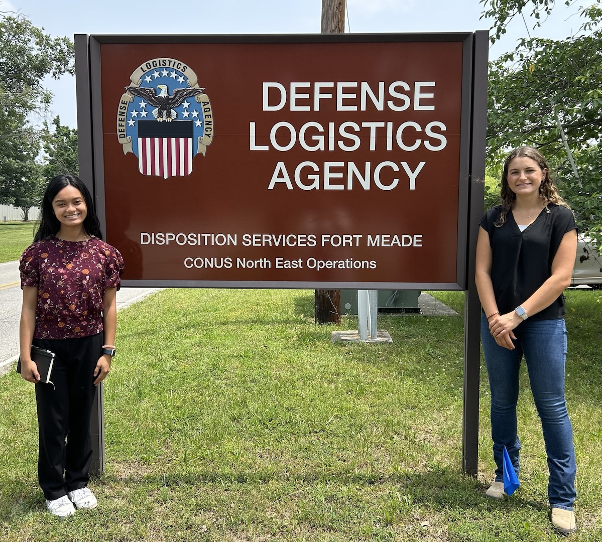 DLA sign with a person standing on each side