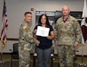 Liz Serra shakes hands with Col. Joselito “Joe” Lim, commander of the U.S. Army Medical Materiel Agency, following her induction into the Order of Military Medical Merit during a quarterly town hall July 10 at Fort Detrick, Maryland. Also pictured is USAMMA Sgt. Maj. Todd Brenecki. Serra, a 15-year Army veteran, has served in USAMMA’s Distribution Operations Center (DOC) for nearly a decade and led the DOC’s vaccine distribution efforts during the COVID-19 pandemic response.