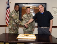 U.S. Army medical logistics leaders gathered July 9 for a cake-cutting ceremony to recognize the 107th birthday of the Army Warrant Officer Corps. Pictured, from left, preparing to cut the cake are Chief Warrant Officer 3 Garron Johnson, medical equipment readiness officer, Army Medical Logistics Command; Col. Joselito “Joe” Lim, commander, U.S. Army Medical Materiel Agency, and Wilmer Tapia, retired chief warrant officer two and current Army Civilian in USAMMA’s Medical Maintenance Management Directorate.