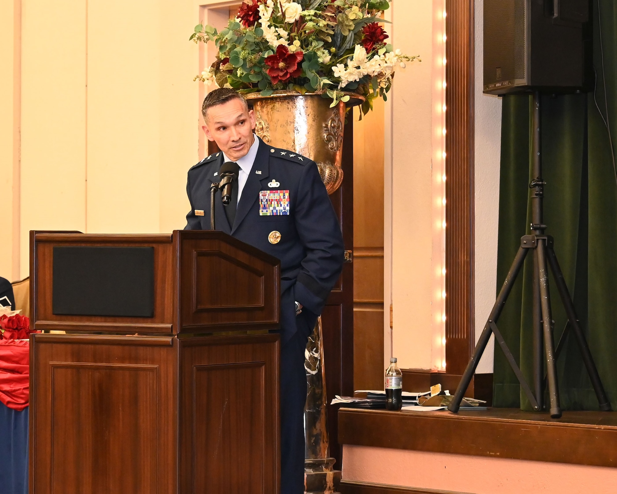 16th Air Force commander speaks to outgoing and incoming 688th CW commanders from podium.