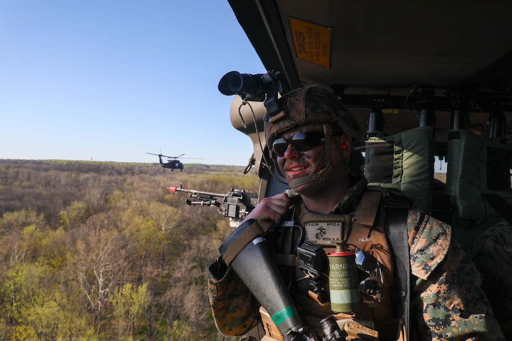 Lance Corporal Nickolas Beem looks out the open-window of the UH-60 Black Hawk during Joint Training Mission ‘Real Deal’ with U.S. Marine Corps Reserves Alpha Co. 4th Law Enforcement Battalion, and Kentucky Air National Guard 123rd Airlift Wing. The objective of the mission was to plan, train, and execute an air assault with a realistic ground force. Aviators from the KYARNG transported Marines on five UH-60 Blackhawks from the Boone National Guard Center in Frankfort, Kentucky, to Camp Atterbury - Muscatatuck in Edinburgh, Indiana. Following the completion of their ground assault, the Marines were transported back to Boone Center by the aviators. The mission highlighted the coordination and operational capabilities of the units involved. (U.S. Army National Guard photo by Spc. Georgia Napier)