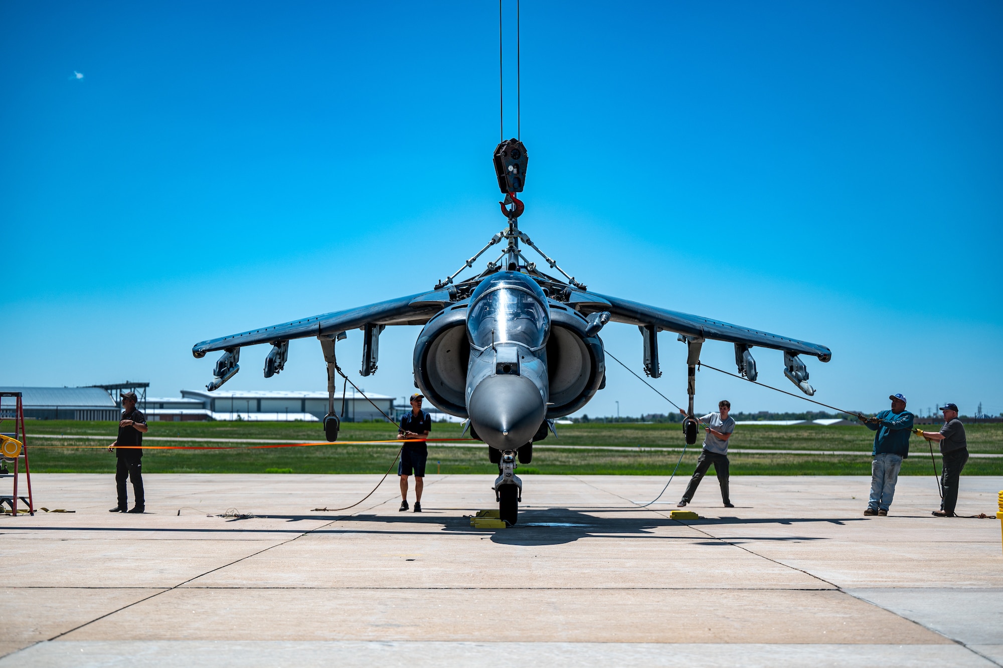 men hold down jet with ropes