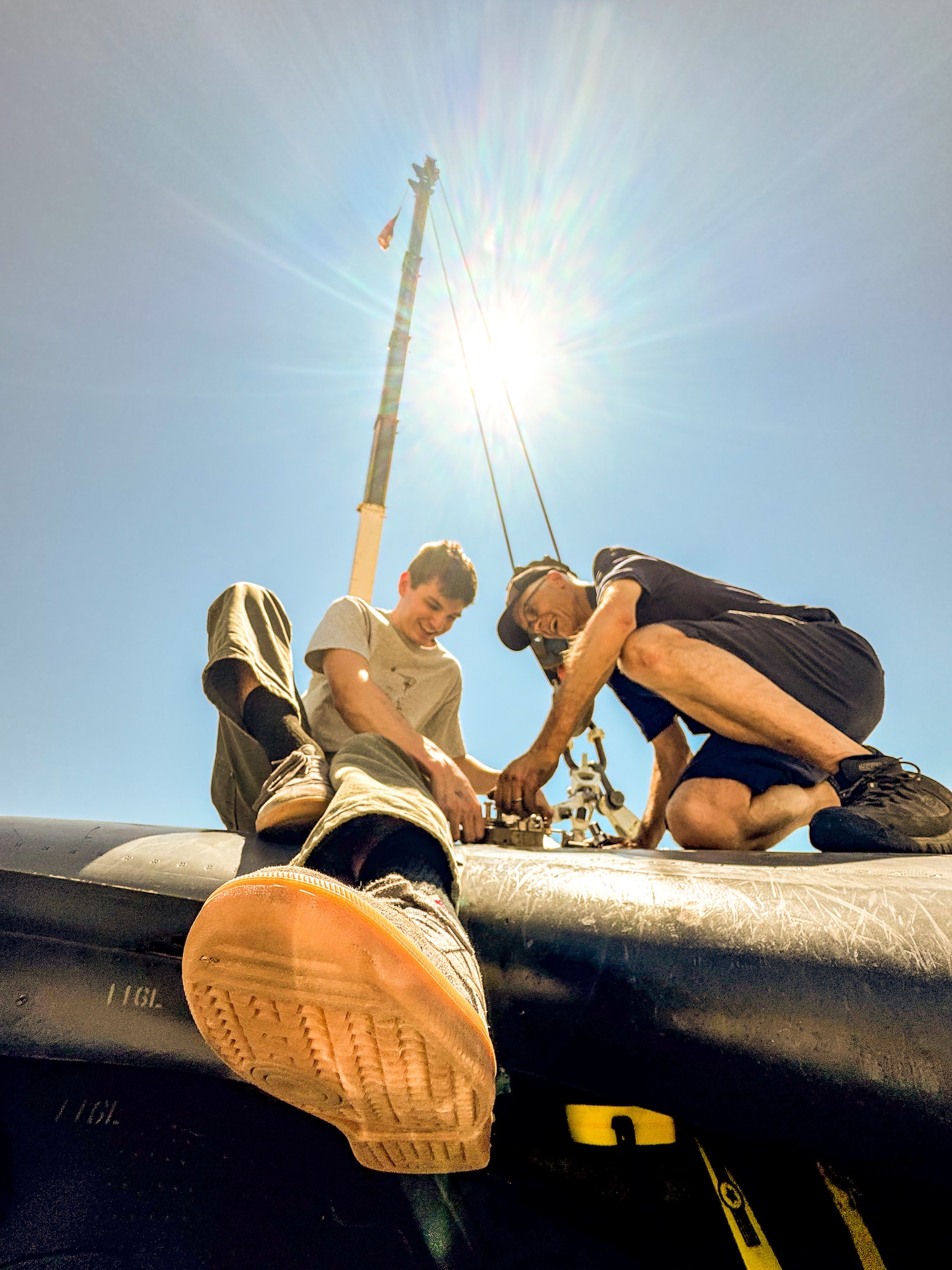 two men use tools on plane