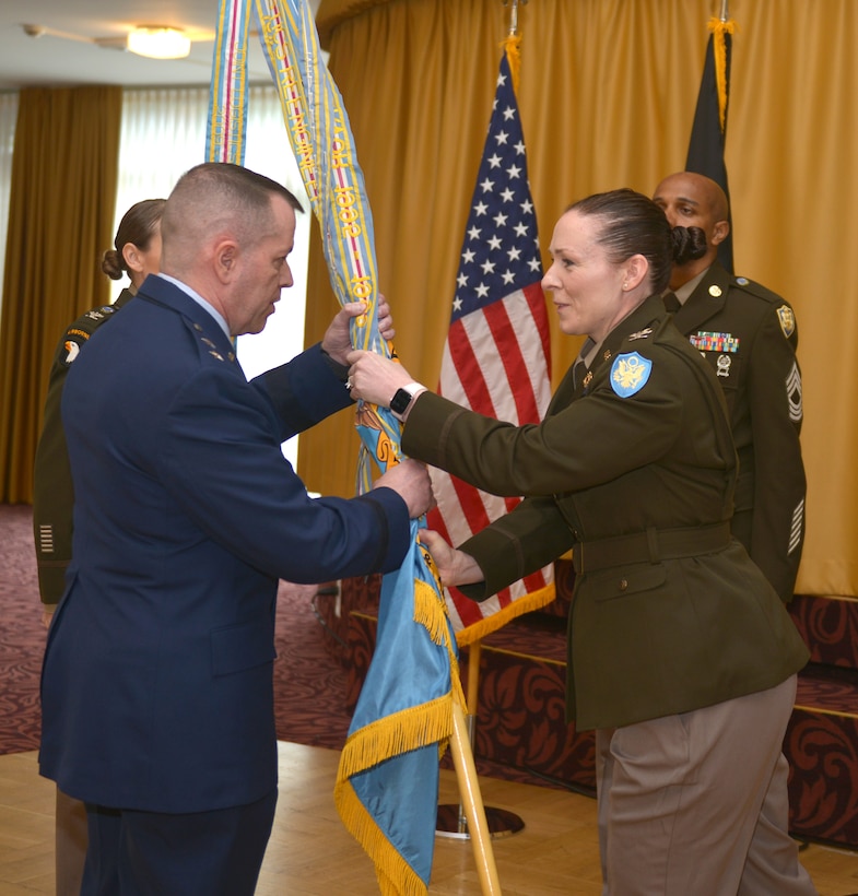 Col. Adrian J. Sullivan passes a flag with the unit colors to Maj. Gen. David Sanford