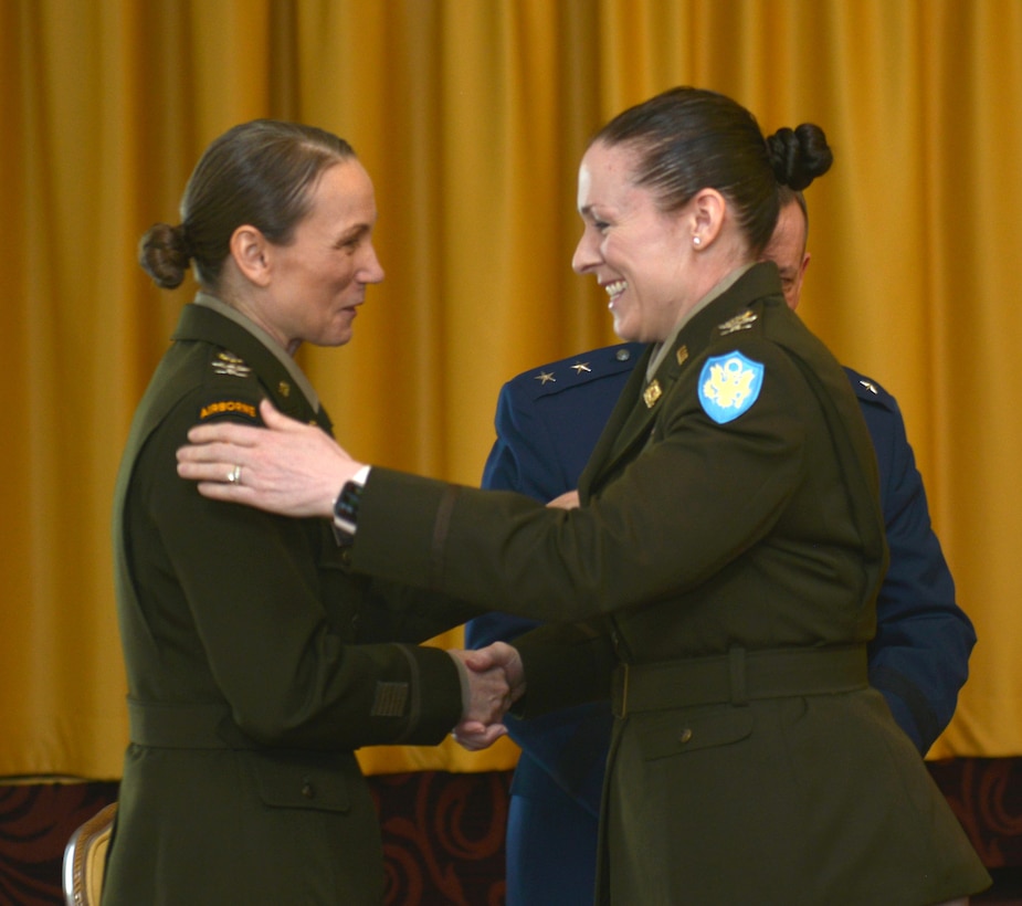 Col. Adrian J. Sullivan and Col. Tracy Yates shake hands in profile