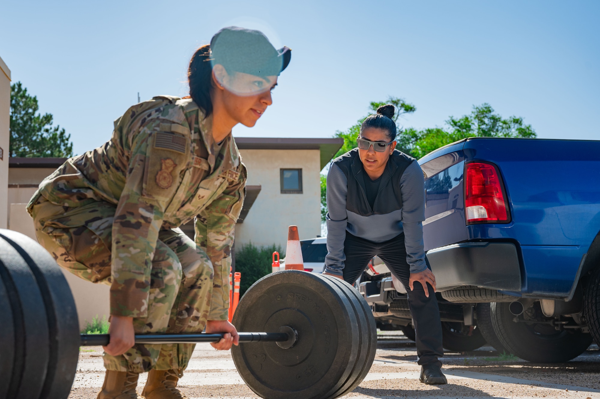 Airmen powerlifting outside with her trainer