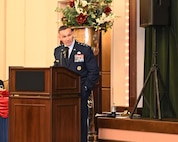 16th Air Force commander speaks to outgoing and incoming 688th CW commanders from podium.