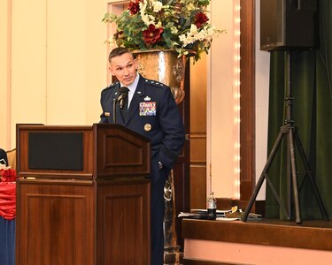 16th Air Force commander speaks to outgoing and incoming 688th CW commanders from podium.