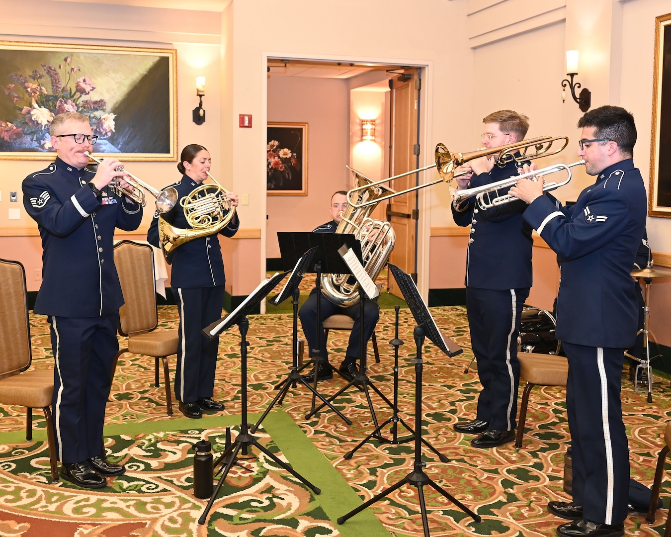Five airmen in uniform play instruments.