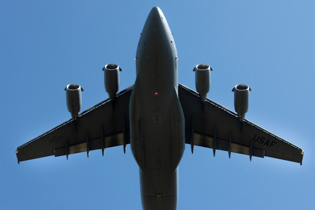 An aircraft flies against a blue sky, as seen from below.