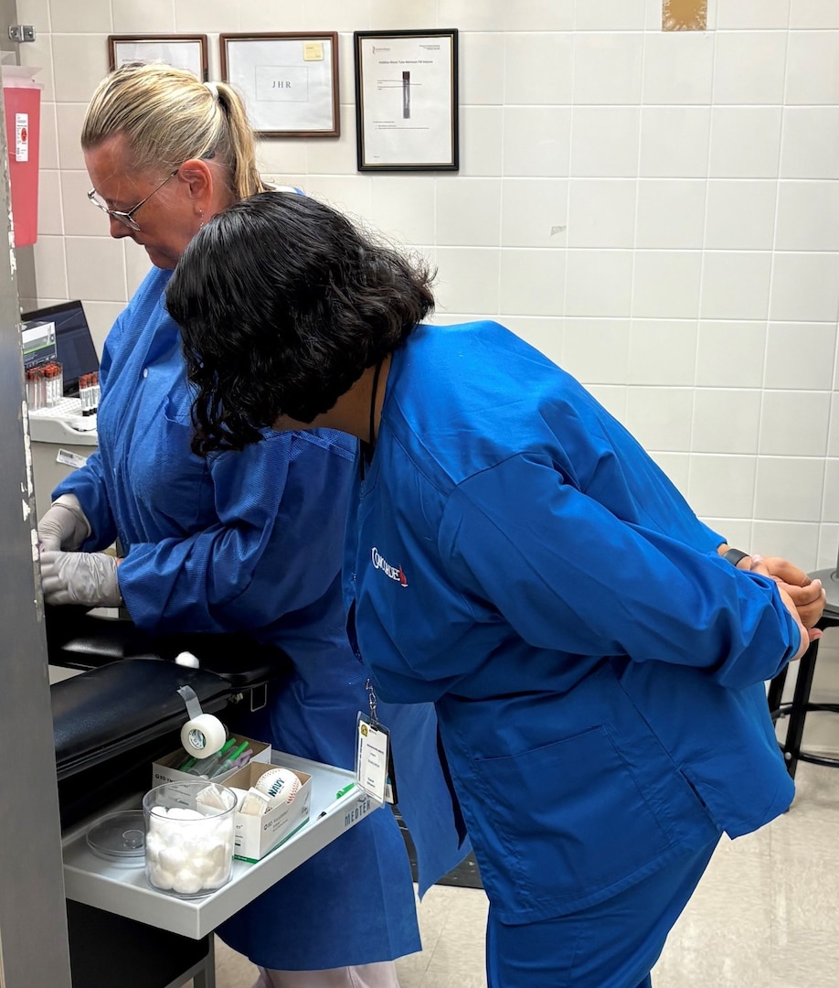 Carol Urbano, phlebotomy extern learns MEPS procedures from Colleen Beagle, medical technician, during externship training. The Jacksonville MEPS team welcomed the first two phlebotomy externs to help assist with collecting vitals, drawing blood and urine samples and conducting vision and audio screenings.