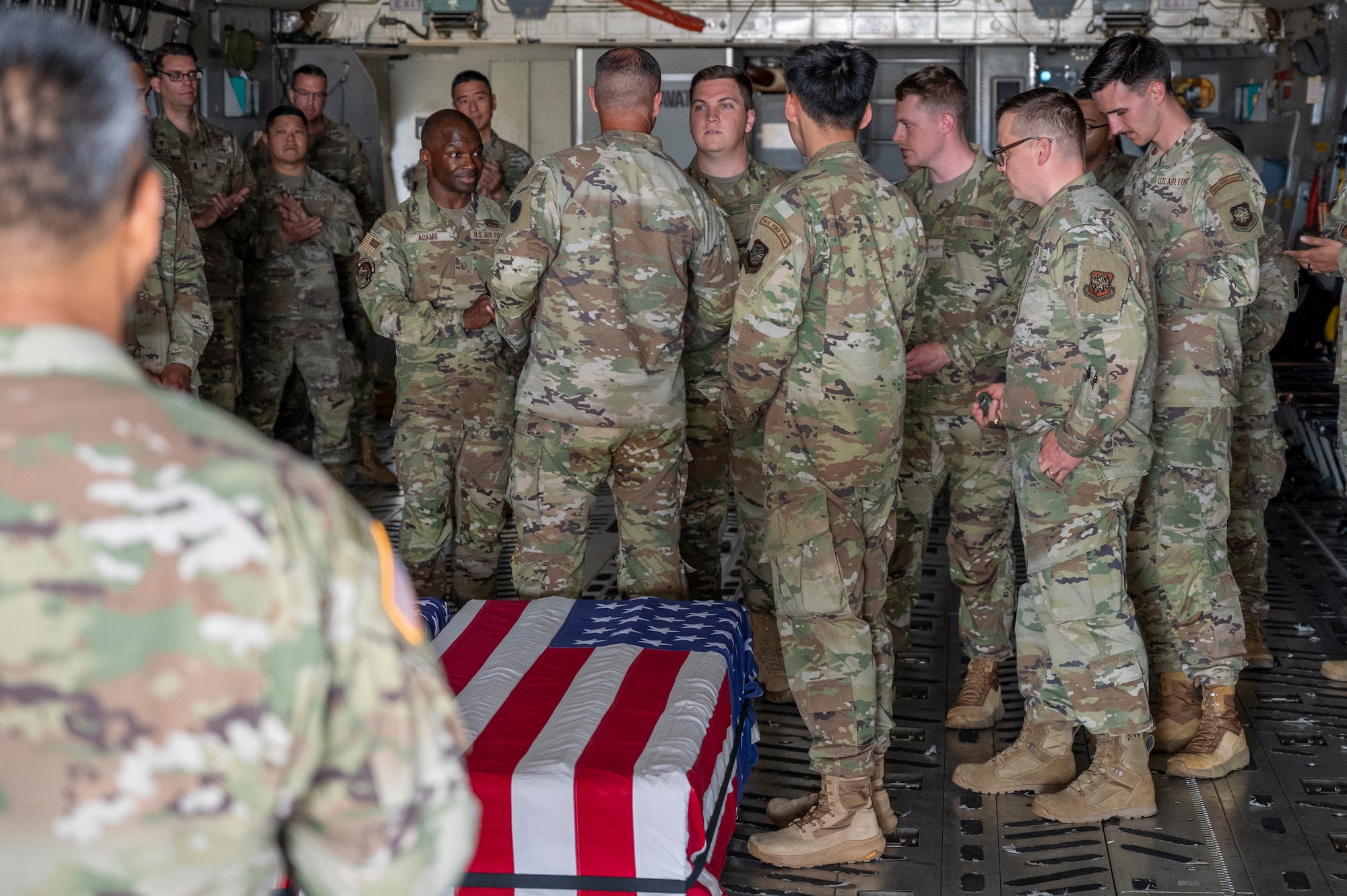 U.S. Army Col. James Foster, Joint Base Lewis-McChord garrison chaplain, coins Senior Airman Jacob Trent, McChord Field Honor Guard guardsman, after a simulated dignified transfer ramp ceremony training at Joint Base Lewis-McChord, Washington, July 10, 2025.