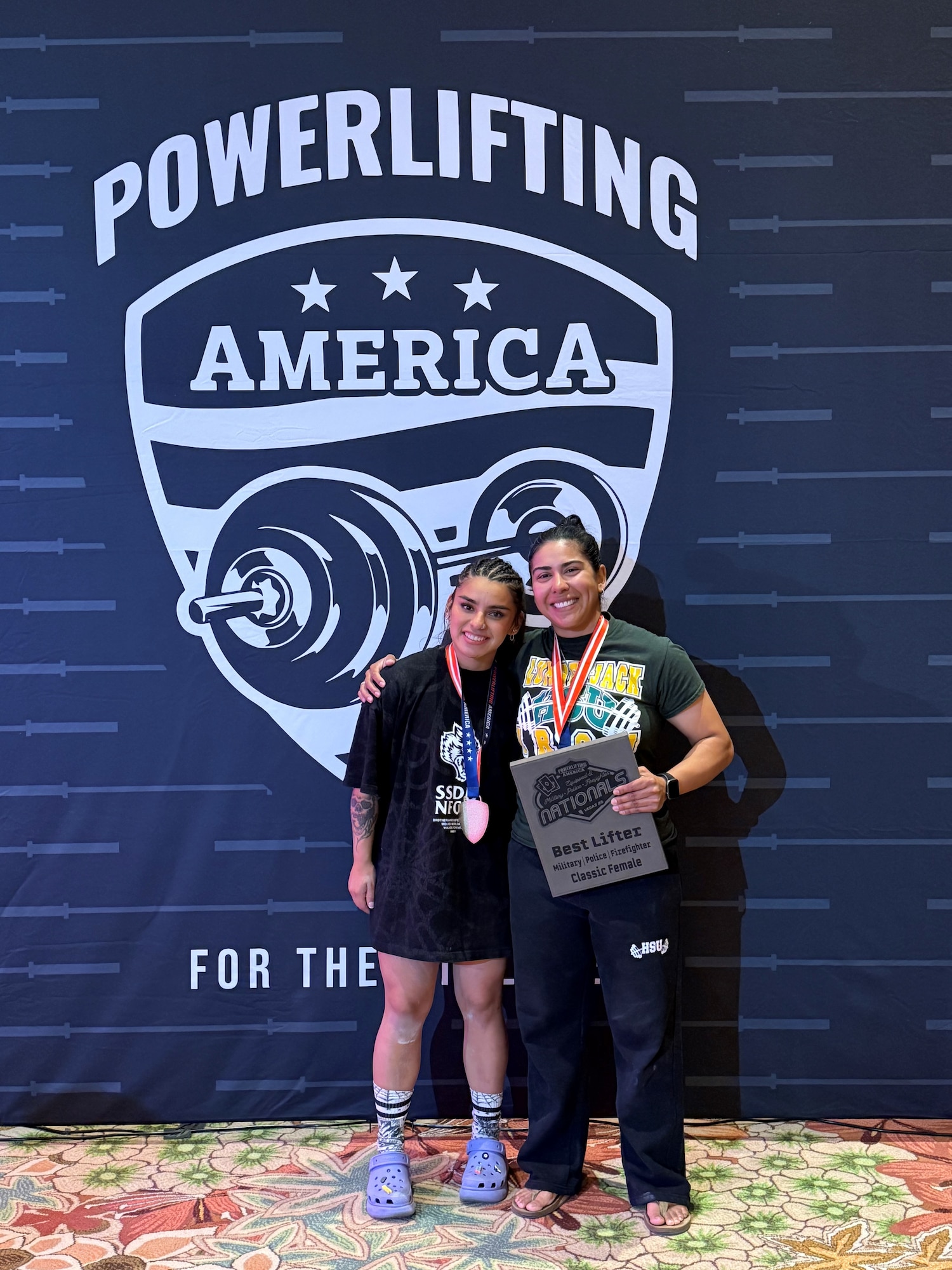 Two women powerlifters pose for photo