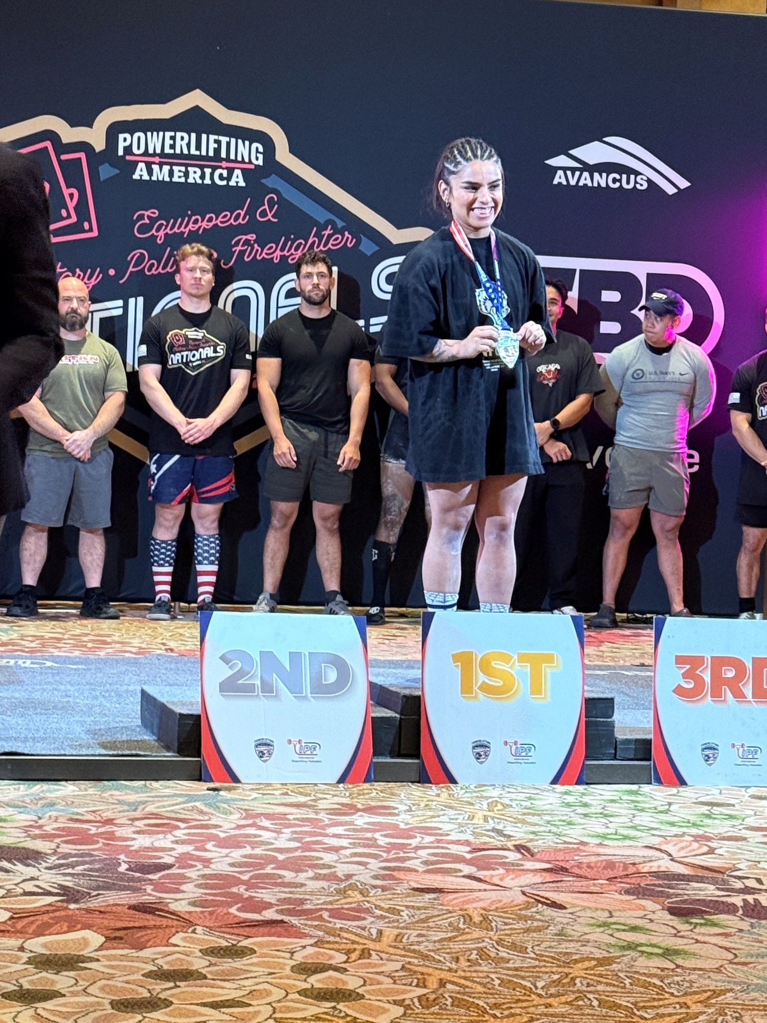 Female powerlifter stands on winner podium