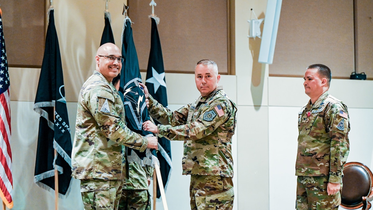 United States Space Force Lt. Gen. David N. Miller, Jr. (left), commander of Space Operations Command, passes the Mission Delta 4 flag to Col. Aaron Cochran (center) at a Change of Command ceremony at Buckley Space Force Base, Colo., July 15, 2025. Cochran took over command of the U.S. Space Force's Missile Warning and Tracking unit from U.S. Space Force Col. Bobby Schmitt (right). (U.S. Space Force photo by Dave Grim)