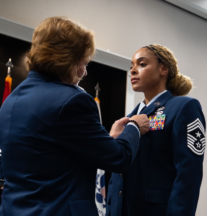 U.S. Air Force Chief Master Sgt. Khamillia Washington, outgoing 17th Training Wing command chief, receives the Legion of Merit from Col. Angelina Maguinness, 17th TRW commander, during the change of responsibility ceremony at the Powell Event Center, Goodfellow Air Force Base, Texas, July 16, 2025. Washington championed for Wing quality of life projects, secured 13 million dollars to replace the failing heat, ventilation and air conditioning system at the Louis F. Garland Department of Defense Fire Academy, obtained 5 million dollars for enhanced combat readiness training, guided the redesigning of a 158 million dollar intelligence exercise and enhanced firefighter performance with a 1.7 million dollar fire protection fleet biometrics project. (U.S. Air Force photo by Airman 1st Class Brian Lummus)