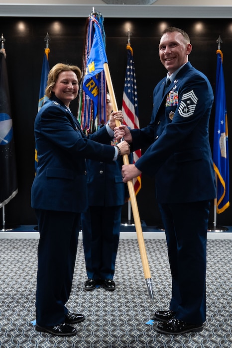 U.S. Air Force Col. Angelina Maguinness, 17th Training Wing commander, passes the guidon to Chief Master Sgt. Derek Neill, incoming 17th TRW command chief, during the change of responsibility ceremony at the Powell Event Center, Goodfellow Air Force Base, Texas, July 16, 2025. Chief Neill will serve as the principal advisor to the 17th TRW commander on all matters concerning the readiness, professional development, utilization and effectiveness of the wing’s enlisted Airmen. (U.S. Air Force photo by Airman 1st Class Brian Lummus)