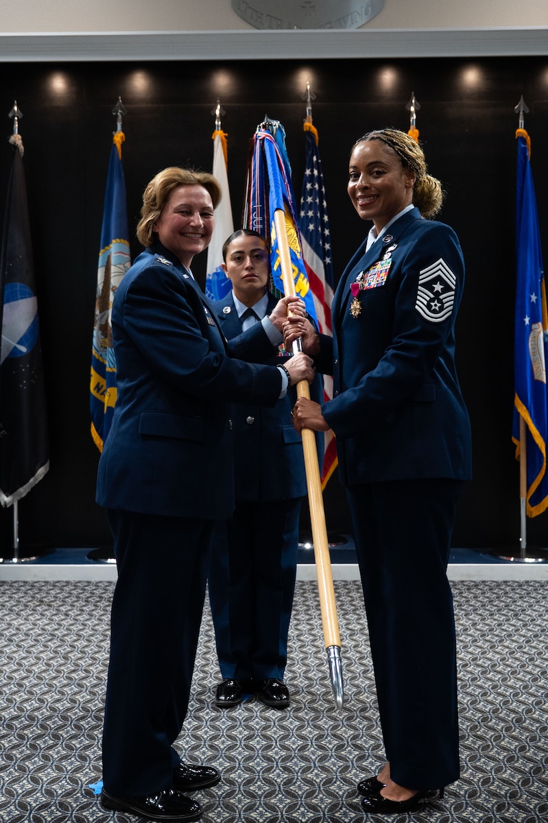 U.S. Air Force Chief Master Sgt. Khamillia Washington, outgoing 17th Training Wing command chief, passes the guidon to Col. Angelina Maguinness, 17th TRW commander, during the change of responsibility ceremony at the Powell Event Center, Goodfellow Air Force Base, Texas, July 16, 2025. The change of responsibility ceremony is steeped in military tradition, serves the function of rendering honors to the departing senior enlisted leader and provides official recognition of the transfer of responsibility to the incoming senior enlisted leader. (U.S. Air Force photo by Airman 1st Class Brian Lummus)