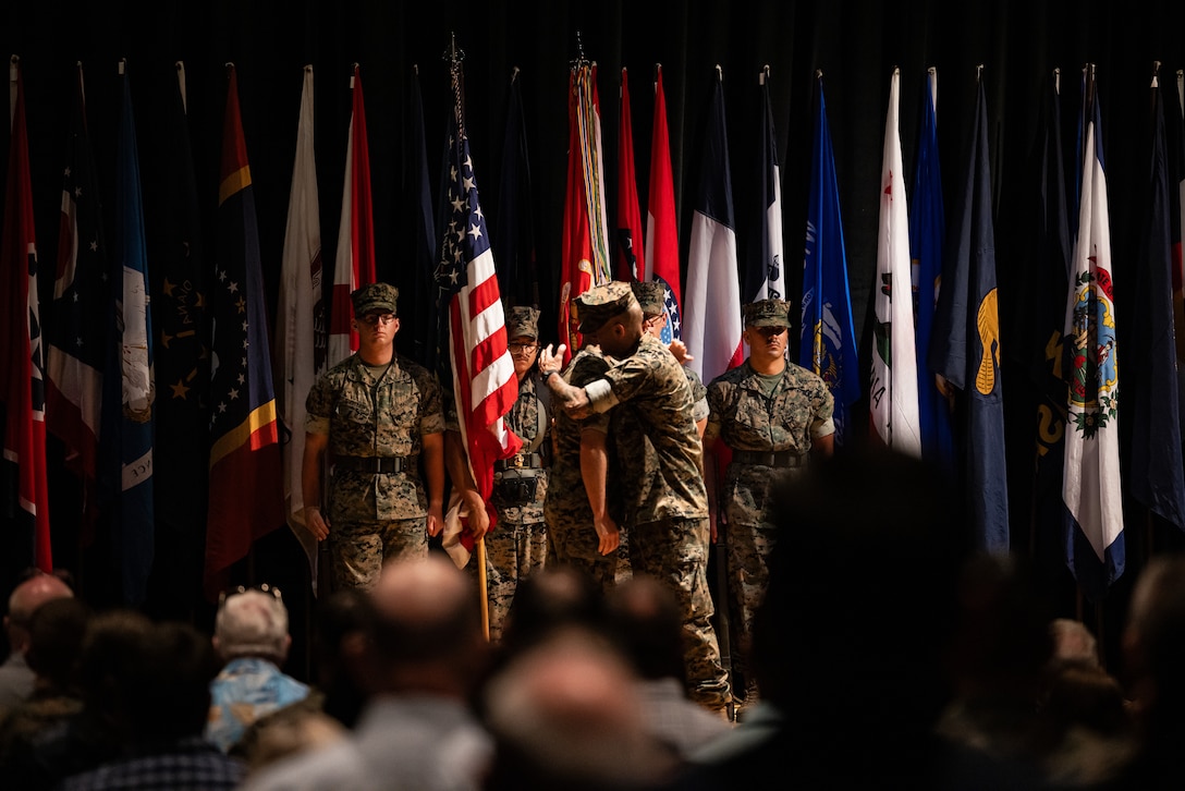 U.S. Marine Corps Col. Thomas Farrington II, center left, incoming commanding officer, embraces Col. Garth W. Burnett, outgoing commanding officer, Marine Corps Air Station (MCAS) New River, during a change of command ceremony at MCAS New River in Jacksonville, North Carolina, July 17, 2025. The ceremony represented the transfer of responsibility, authority and accountability from the outgoing to the incoming commanding officer. (U.S. Marine Corps photo by Cpl. Loriann Dauscher)