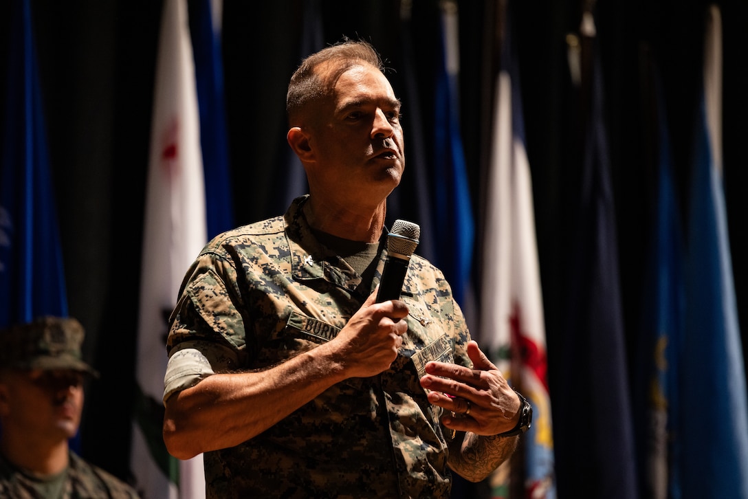 U.S. Marine Corps Col. Garth W. Burnett, outgoing commanding officer, Marine Corps Air Station (MCAS) New River, gives his remarks during a change of command ceremony at MCAS New River in Jacksonville, North Carolina, July 17, 2025. The ceremony represented the transfer of responsibility, authority and accountability from the outgoing to the incoming commanding officer. (U.S. Marine Corps photo by Cpl. Loriann Dauscher)