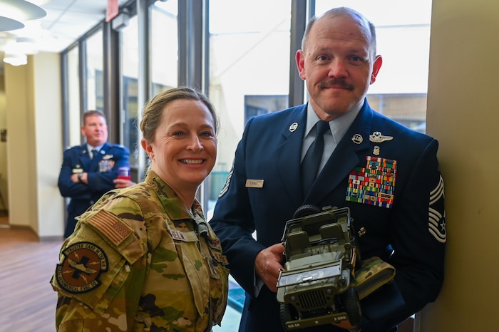 Chief Master Sgt. Jeremy Everly, 433rd Aeromedical Evacuation Squadron senior enlisted leader, poses for a photo with Capt. Courtney Helm, a 433rd AES flight nurse, and the toy Jeep he is charged with caring for as part of the Jeep Chief tradition at Joint Base San Antonio-Lackland, Texas, July 12, 2025.