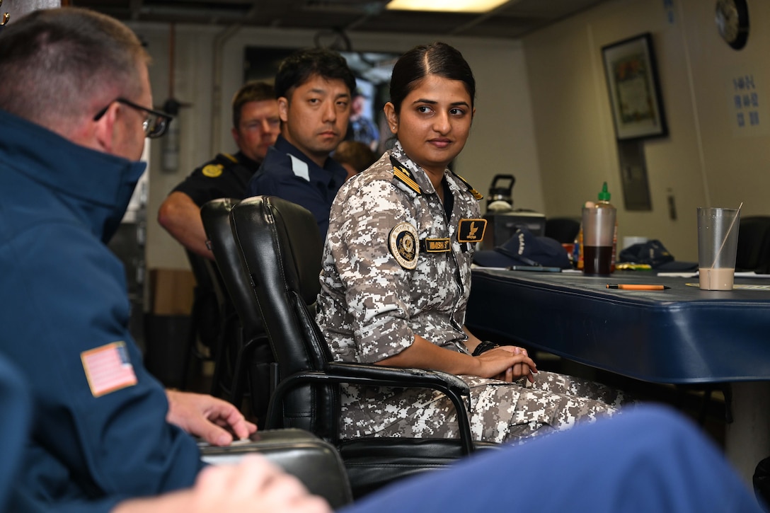 Nimisha Soparkar, right, assistant commandant, Indian Coast Guard, listens to Cmdr. Jonathan Wolstenholme, left, executive officer of the Legend-class U.S. Coast Guard Cutter Stratton (WMSL 752), in Stratton’s wardroom during talks with the Quad partners while Stratton patrols the Pacific Ocean, July 1, 2025. Stratton is deployed and assigned to Destroyer Squadron (DESRON) 15, the Navy’s largest DESRON and the U.S. 7th Fleet’s principal surface force. Stratton is deployed to the Indo-Pacific to advance relationships with ally and partner nations to build a more secure and prosperous region with unrestricted, lawful access to the maritime commons. (U.S. Coast Guard photo by Petty Officer 2nd Class Kate Kilroy)