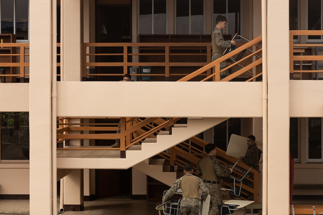 U.S. Marines with Combat Logistics Battalion 15, Combat Logistics Regiment 17, 1st Marine Logistics Group, move desks back to classrooms after the Pacific Mini Games during Koa Moana 25 at Meyuns Elementary School in Palau, July 15, 2025.