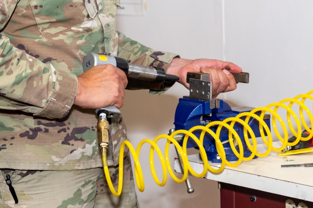 Close up Airmen using rivet gun