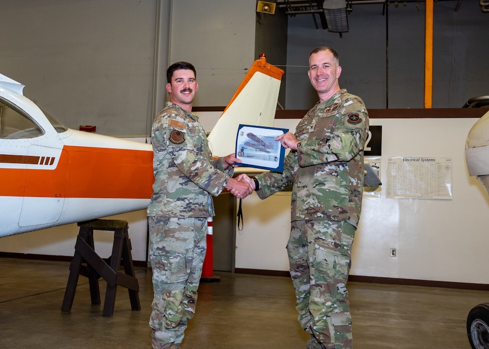 A group commander presents instructor with certificate