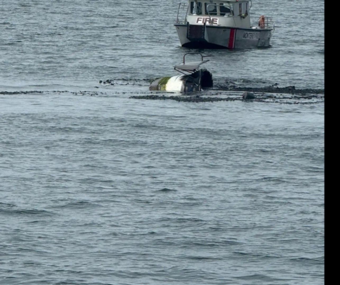 A boat's stern is seen just above the surface of the water as it sinks.