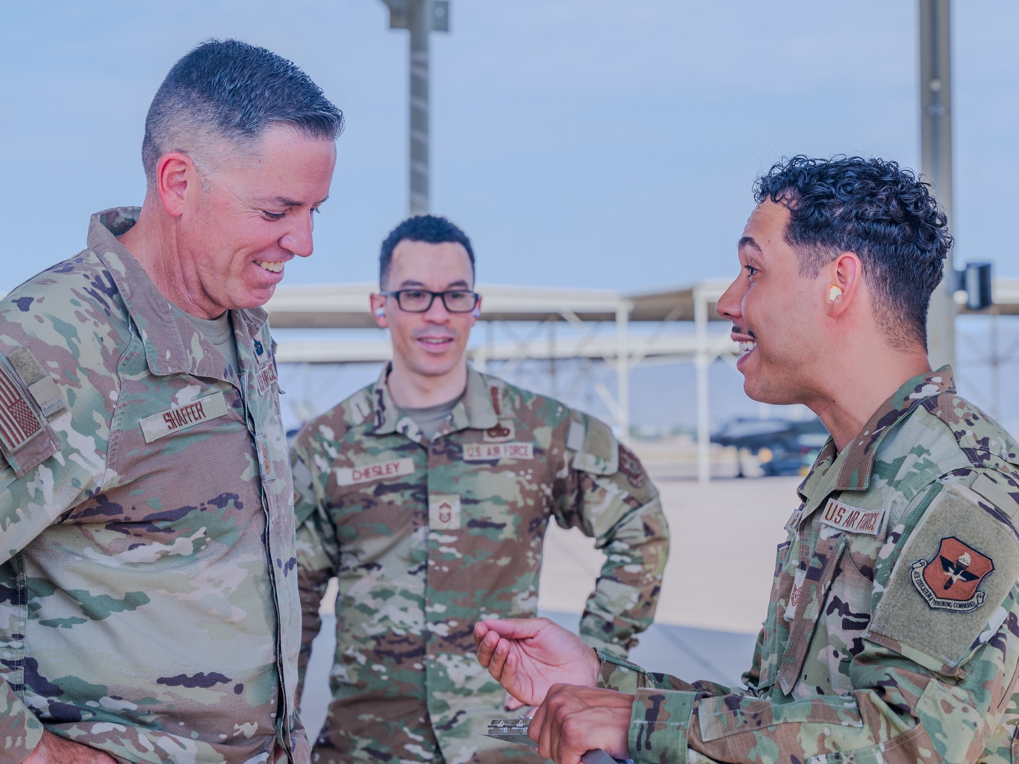 U.S. Air Force Chief Master Sgt. Jason Shaffer (left), 56th Fighter Wing command chief, accompanied by Chief Master Sgt. Derrick Chesley (center), 944th Aircraft Maintenance Squadron wing weapons manager, receives feedback from Tech. Sgt. Raul Guzman (right), 56th Maintenance Group F-35 qauality assurance inspector, after launching a jet on the flightline, July 16, 2025, at Luke Air Force Base, Arizona.