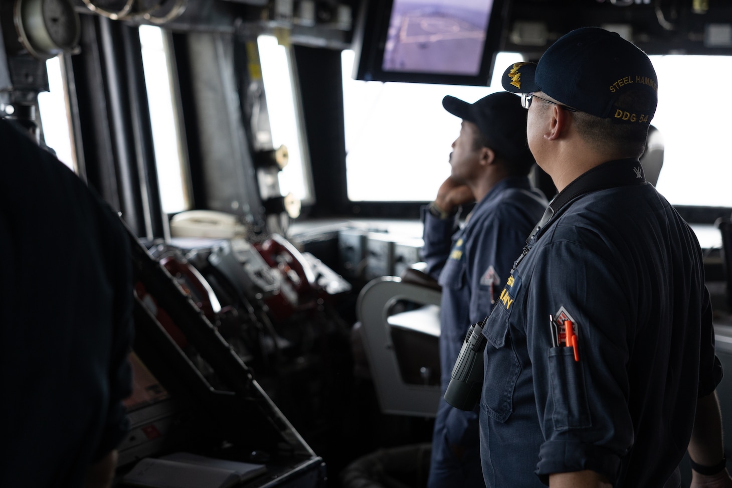 SOUTH CHINA SEA - Cmdr. Yilei Liu, commanding officer of the Arleigh Burke-class guided-missile destroyer USS Curtis Wilbur (DDG 54), looks out from the bridge during bilateral Maritime Cooperative Activity with the Armed Forces of the Philippines and the Philippine Coast Guard in the South China Sea, July 16, 2025. Curtis Wilbur is assigned to Destroyer Squadron (DESRON) 15, the Navy’s largest DESRON and U.S. 7th Fleet’s principal surface force. (U.S. Navy photo by Mass Communication Specialist Seaman Mark Bergado)