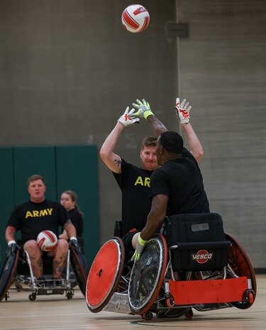 U.S. Army Staff Sgt. Coty Tuck, center-right, and Master Sgt. Earlie Brown, right, compete for the ball as Staff Sgt. Tyler Pollard, left, and Capt. Samantha Frey, center-left, watch the action while conducting drills at wheelchair rugby practice.