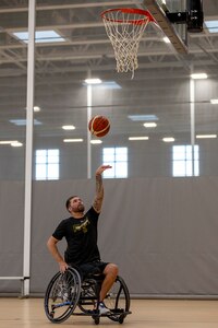 U.S. Army Staff Sgt. John Michael Britton shoots the basketball while participating in drills at wheelchair basketball practice during the 2025 Department of Defense Warrior Games practice sessions at Fort Carson, Colorado, July 14, 2025.