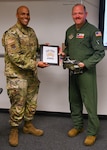 Chief Master Sgt. Jonathan Birk (left), 433rd Airlift Wing command chief, presents the items associated with the Jeep Chief tradition to Chief Master Sgt. Jeremy Everly (right), 433rd Aeromedical Evacuation Squadron senior enlisted leader, during an informal ceremony at Joint Base San Antonio-Lackland, Texas, July 12, 2025. The tradition, rooted in decades of Air Force enlisted culture, designates the most recently promoted chief master sergeant in a unit as a “chief in upgrade training.” (U.S. Air Force photo by Julian Hernandez)