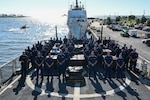 The crew of USCGC Resolute (WMEC 620) pose for a group photo during a drug offload at Coast Guard Sector St. Petersburg, July 17, 2025. Resolute deployed in support of Joint Interagency Task Force-South (JIATF-South), an interagency and international task force that conducts counter-illicit trafficking and security cooperation operations in the Caribbean Sea and Atlantic and Pacific Oceans. (U.S. Coast Guard photo by Petty Officer 1st Class Riley Perkofski)