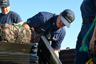U.S. Coast Guard Lt. Logan Sullivan, an engineering officer assigned to USCGC Resolute (WMEC 620), wraps bails of illicit narcotics during a drug offload at Coast Guard Sector St. Petersburg, July 17, 2025. Resolute’s crew offloaded nearly 12,600 pounds of cocaine, worth an estimated $93.2 million following a 59-day patrol in the Eastern Pacific. (U.S. Coast Guard photo by Petty Officer 1st Class Riley Perkofski)