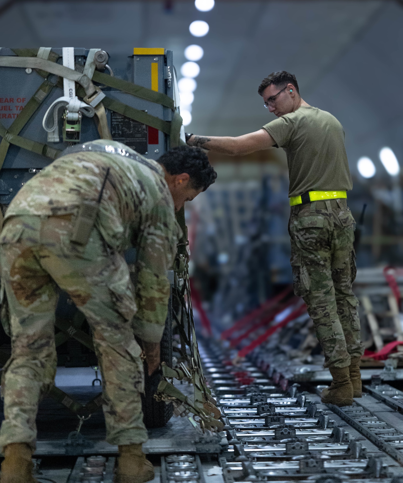 U.S. Air Force Airmen secure cargo on to a Boeing 747 Aircraft