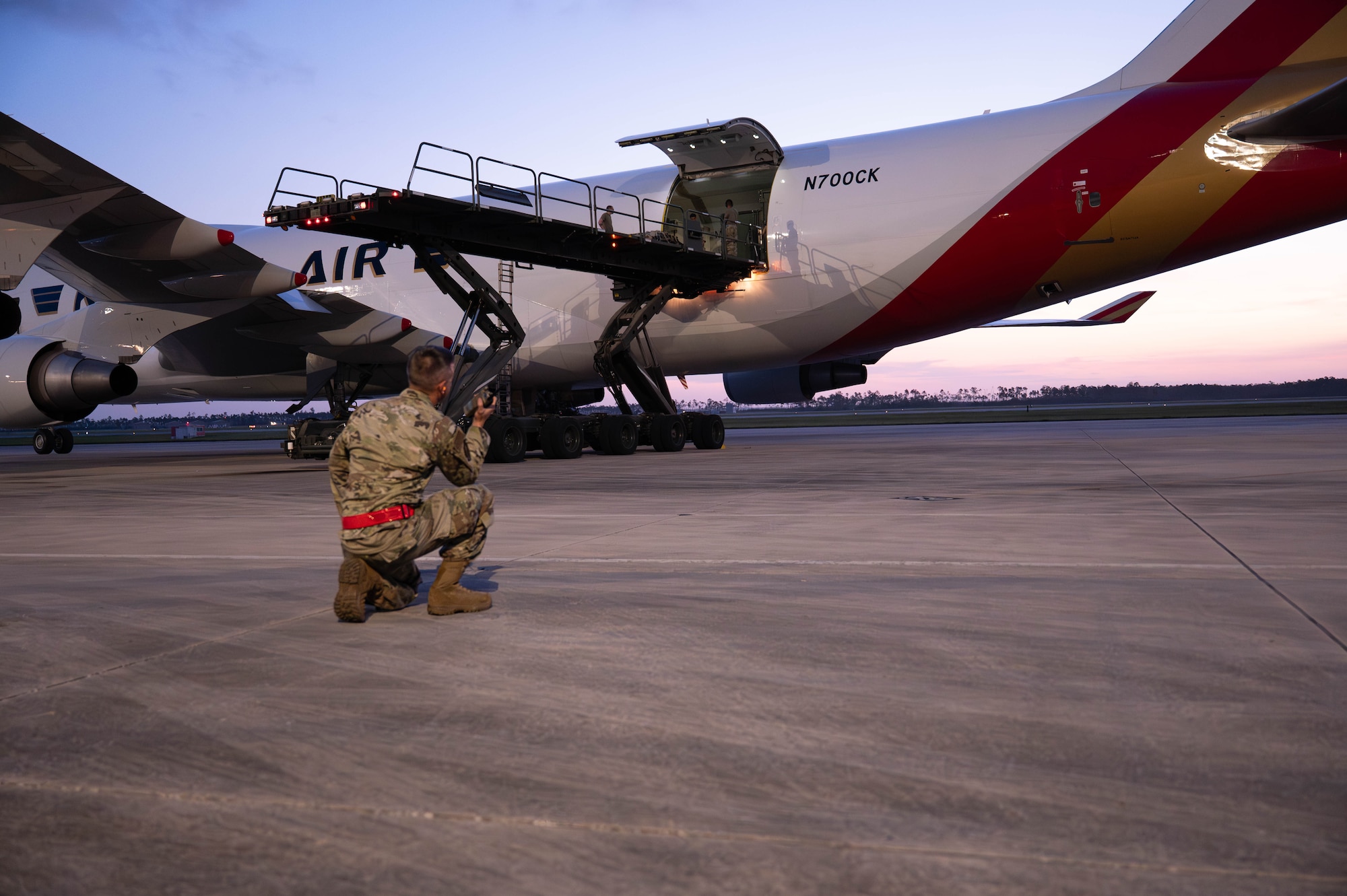 U.S. Air Force 2nd Lt. Mark Garaguso, 325th Logistics Readiness Squadron directs Airmen loading cargo onto a Boeing 747 aircraft.