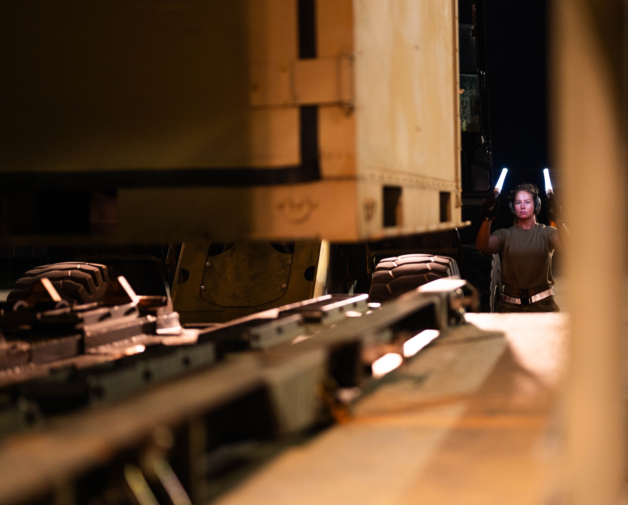 U.S. Air Force Staff Sgt. Alyssa Stokley, 325th Logistics Readiness Squadron air transportation function craftsman, directs a forklift driver to load cargo onto a Tunner 25K loader at Tyndall Air Force Base, Florida.