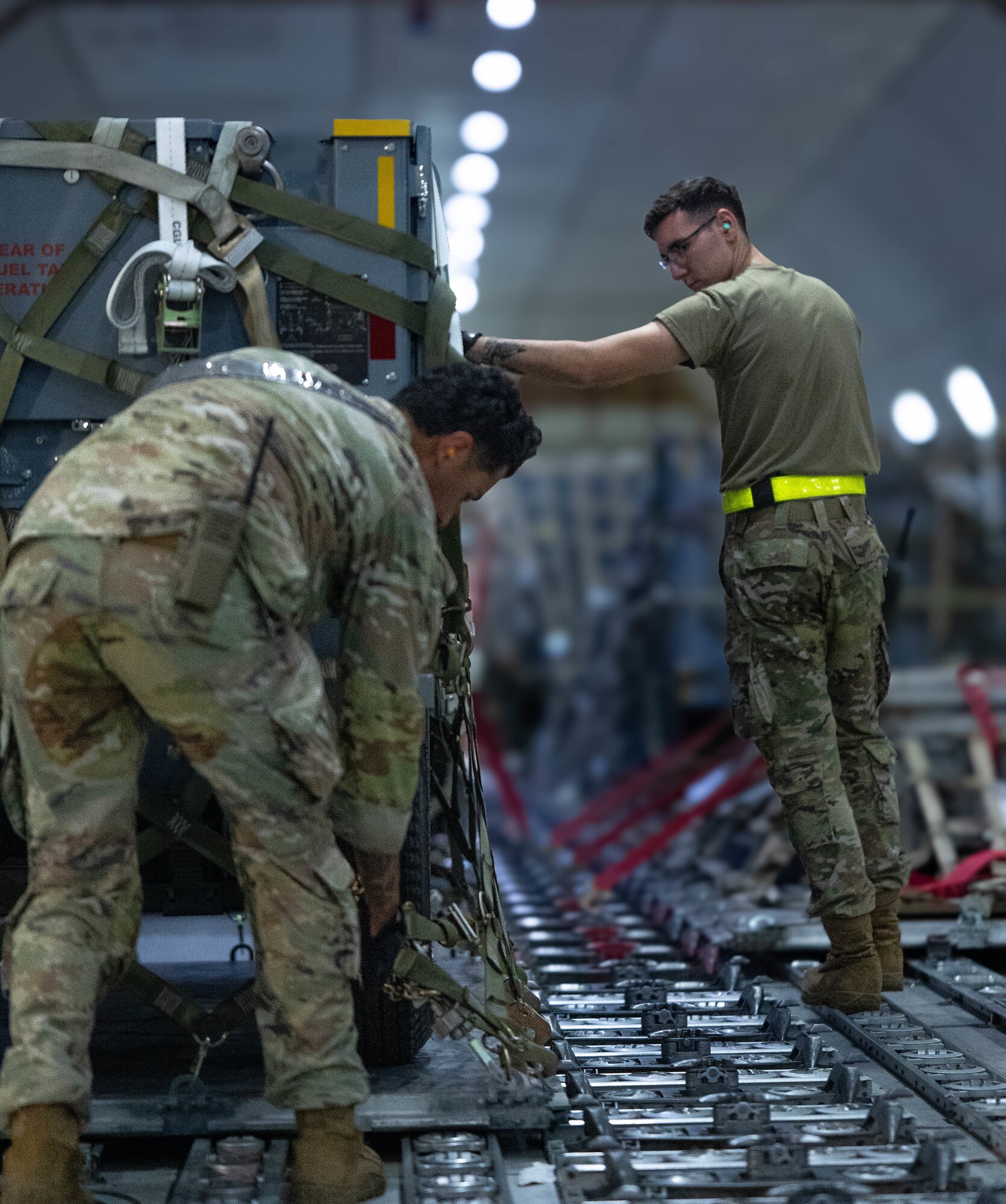U.S. Air Force Airmen secure cargo on to a Boeing 747 Aircraft