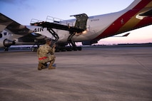 U.S. Air Force 2nd Lt. Mark Garaguso, 325th Logistics Readiness Squadron directs Airmen loading cargo onto a Boeing 747 aircraft.