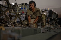 U.S. Air Force Senior Airman Christopher Geer Jr., 325th Logistics Readiness Squadron air transportation function craftsman, secures cargo onto a Tunner 60K loader at Tyndall Air Force Base, Florida.
