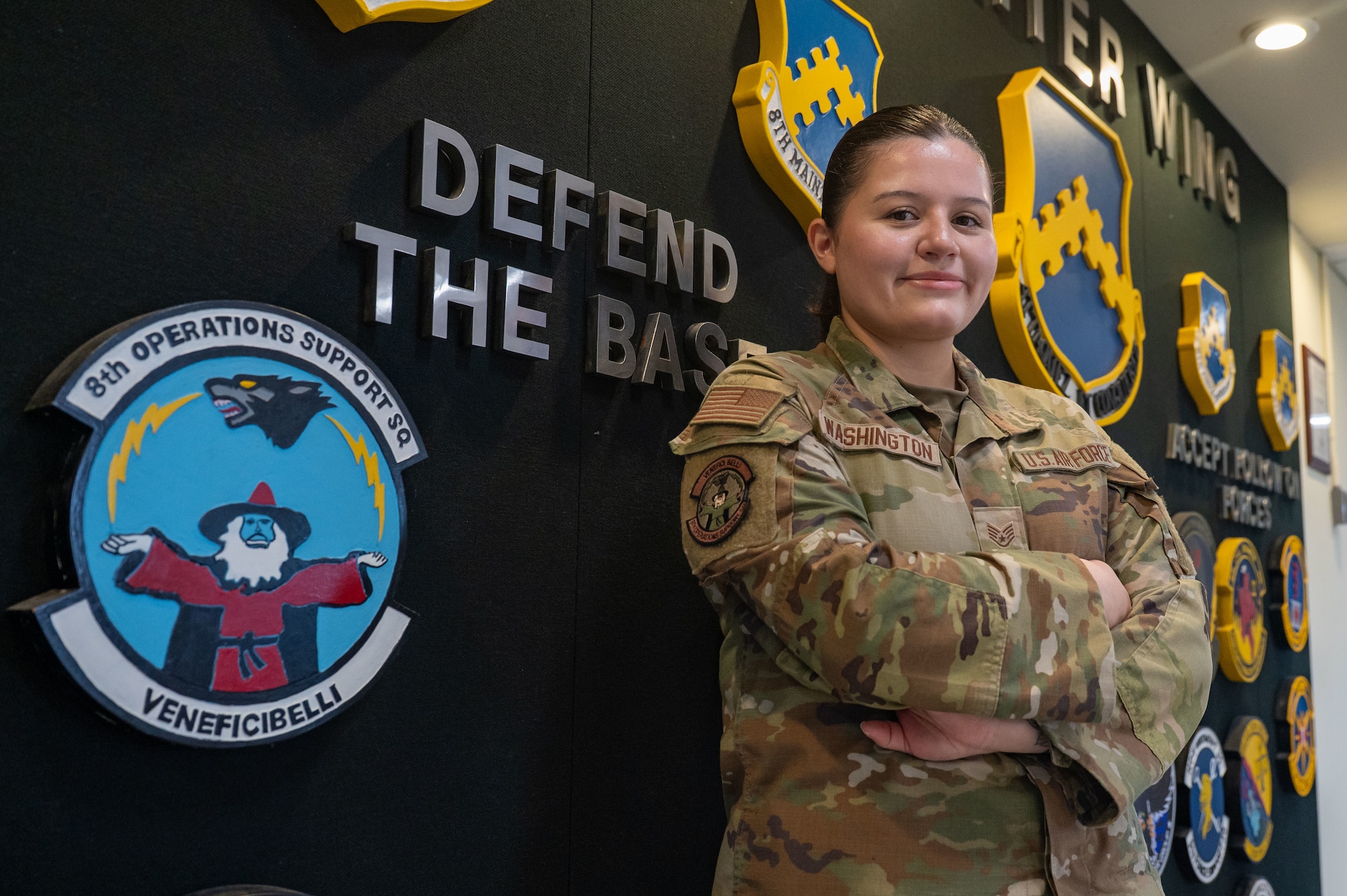 U.S. Air Force Staff Sgt. Alexandria Washington poses for a photo with her 8th OSS Logo