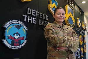 U.S. Air Force Staff Sgt. Alexandria Washington poses for a photo with her 8th OSS Logo