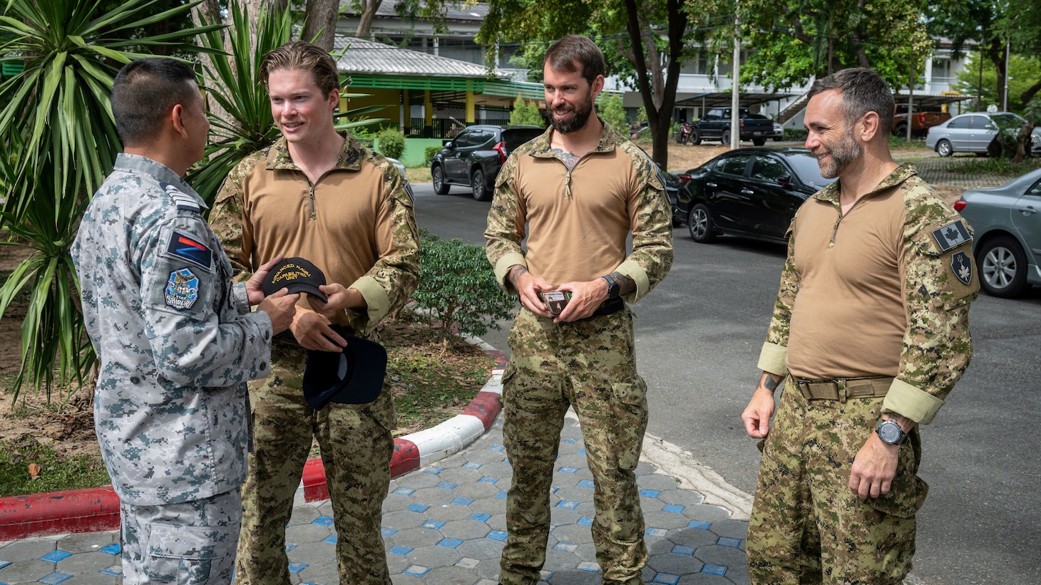 U.S. Navy, Royal Canadian Navy, and Royal Thai Navy personnel pose for a group photo during the closing ceremony for Cooperation Afloat Readiness and Training (CARAT) Thailand 2025 at Sattahip Naval Base, Thailand, July 16, 2025. This year marks the 31st iteration of CARAT, a multinational exercise series designed to enhance U.S. and partner navies' abilities to operate together in response to traditional and non-traditional maritime security challenges in the Indo-Pacific region. (U.S. Marine Corps photo by Sgt. Mitchell Johnson)