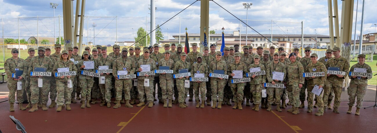 A group photo of service members holding certificates and plaques.